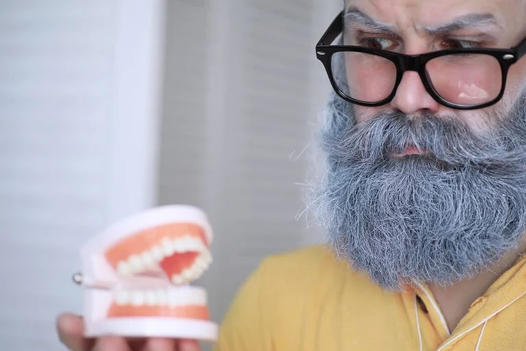 Cheerful hipster man with a white beard. Surprised man with glas